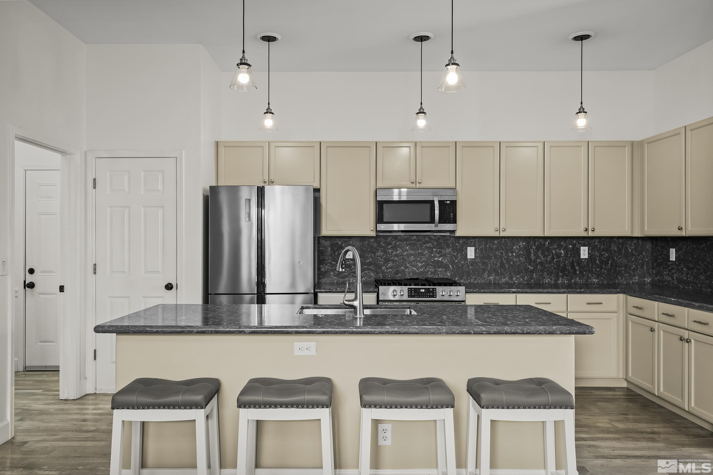 10245 Grizzly Hill Court Reno, NV 89521 - Photo 7 of 40 a kitchen with stainless steel appliances granite countertop a kitchen island hardwood floor sink and stove