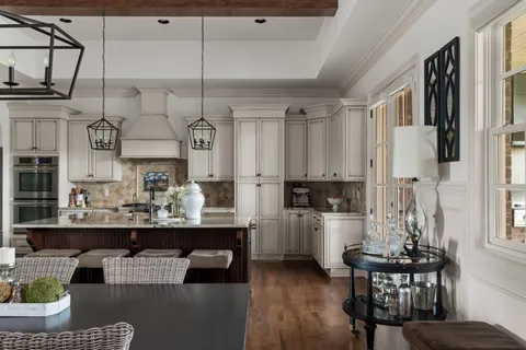 a kitchen with stainless steel appliances kitchen island granite countertop a table chairs in it and wooden floors