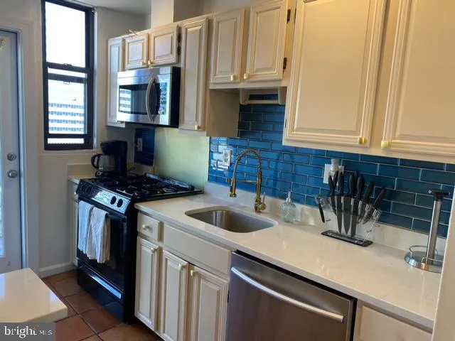 a kitchen with sink a microwave and cabinets