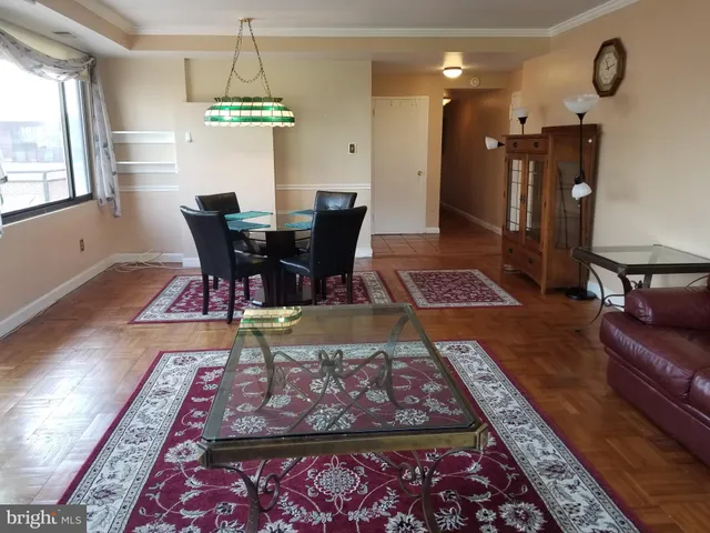a living room with dining table and a rug
