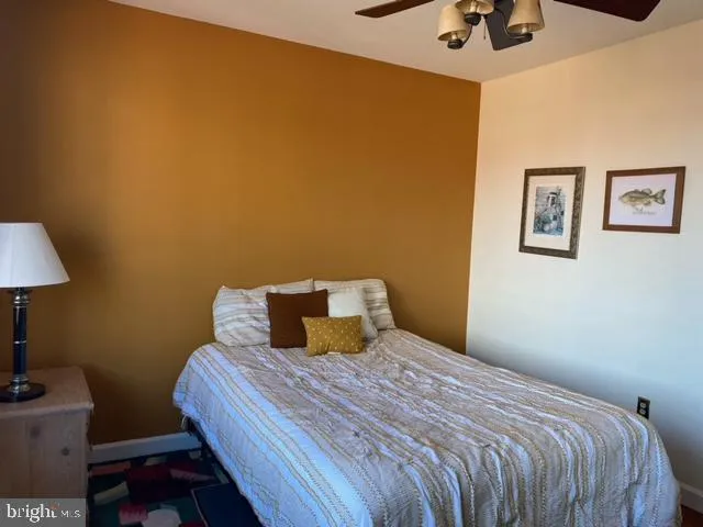 a bedroom with a bed and a lamp on the dresser