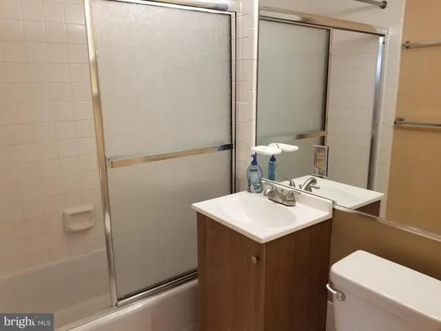 a bathroom with a sink a toilet a mirror and shower