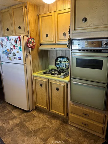 a kitchen with stainless steel appliances granite countertop a stove and a refrigerator with cabinets