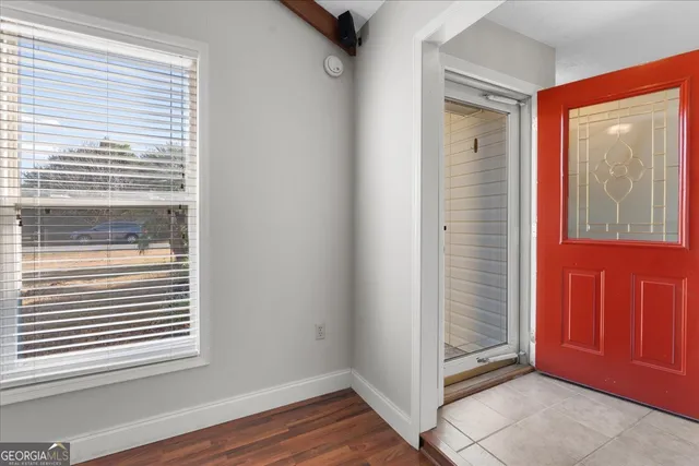 a view of an empty room with wooden floor and fireplace