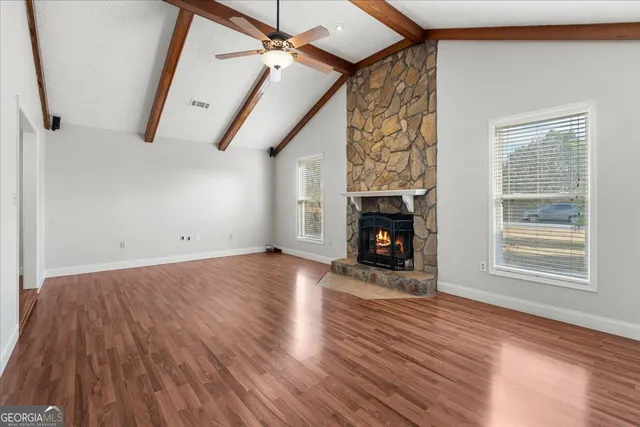 a view of empty room with wooden floor and fireplace