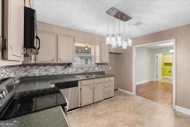 a kitchen with granite countertop a sink stove and refrigerator