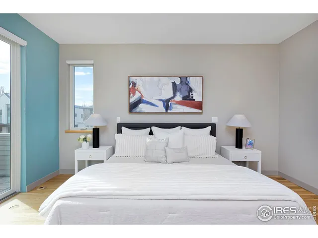 a bedroom with a bed and a painting on the wall