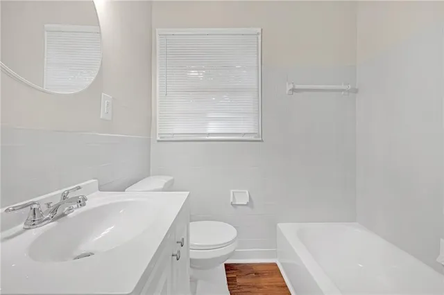 a bathroom with a sink a toilet and a mirror