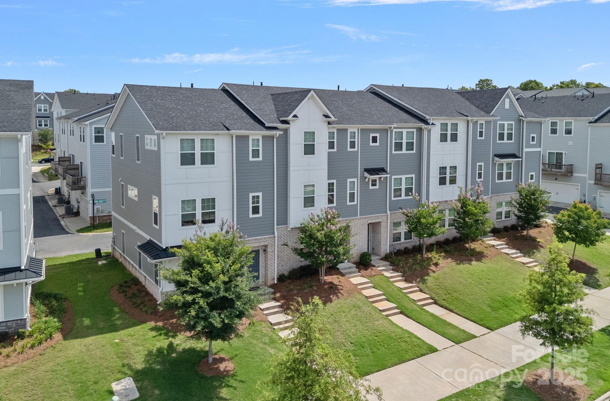 2426 Arbor Loop Drive Charlotte, NC 28217 - Photo 2 of 23 a view of a white house next to a yard with potted plants