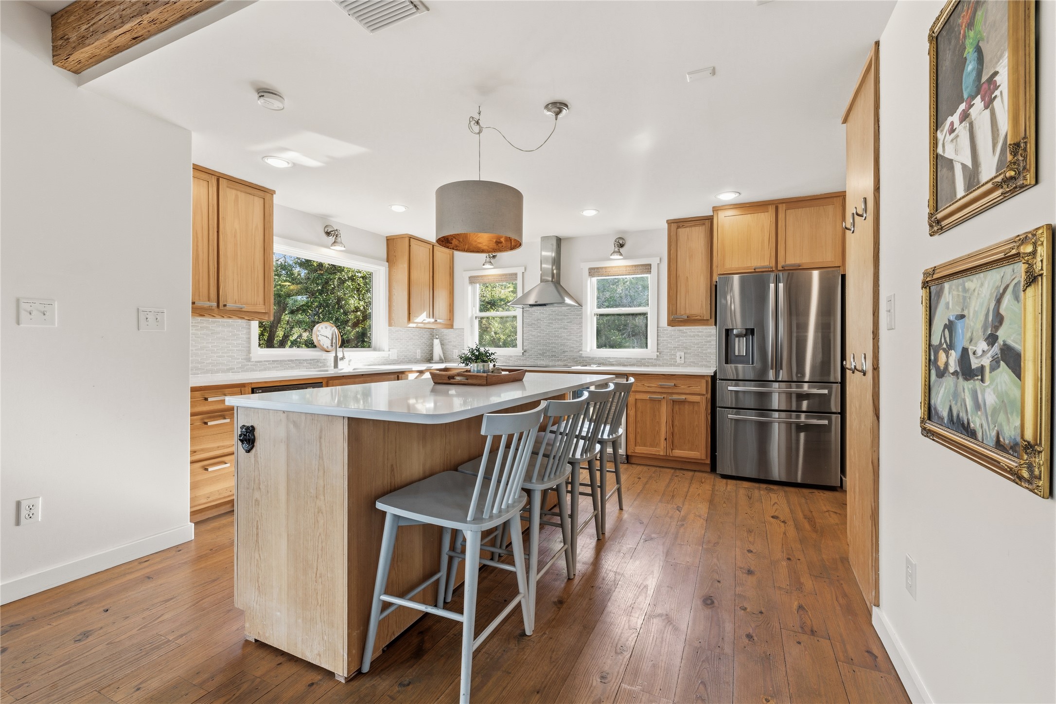 12901 Wire Road Leander, TX 78641 - Photo 4 of 40 Gleaming hardwood floors and a spacious central island anchor this light-filled culinary space.