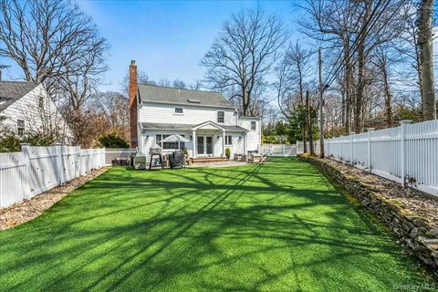 a view of a house with backyard and a tree