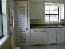 a bathroom with a granite countertop sink and a window