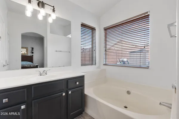 a bathroom with a bathtub sink vanity and a mirror