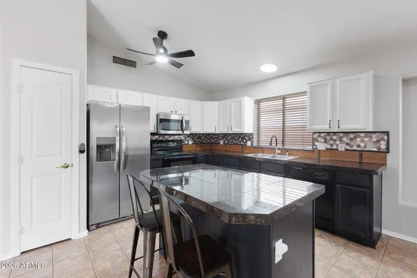 a kitchen with granite countertop a center island and stainless steel appliances