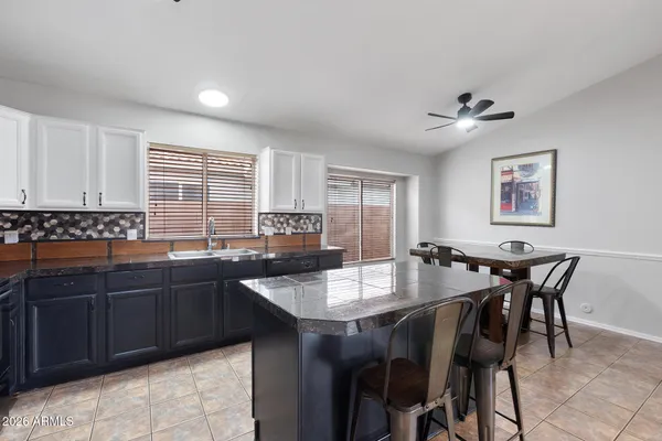 a kitchen with a dining table chairs cabinets and appliances