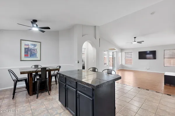 a dining hall with stainless steel appliances granite countertop a sink a counter space and cabinets