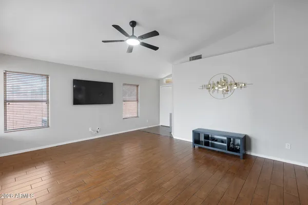 a view of a livingroom with wooden floor and a ceiling fan