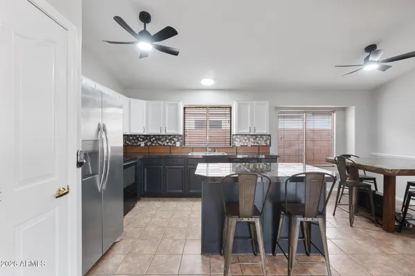 a kitchen with refrigerator cabinets dining table and chairs