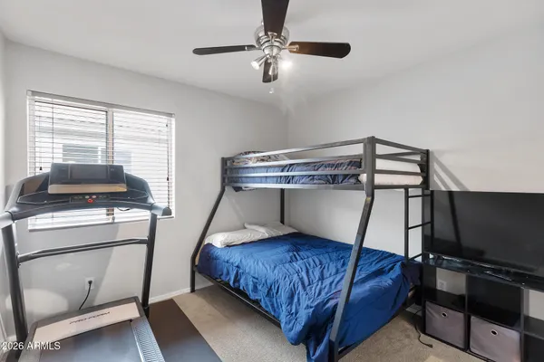 a bedroom with a bed and a flat tv screen on the dresser