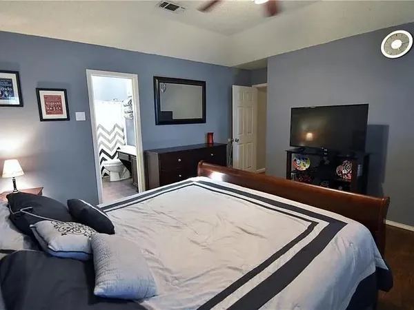 a bedroom with a bed and a flat screen tv