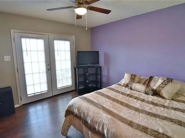 a spacious bedroom with a bed and a flat screen tv
