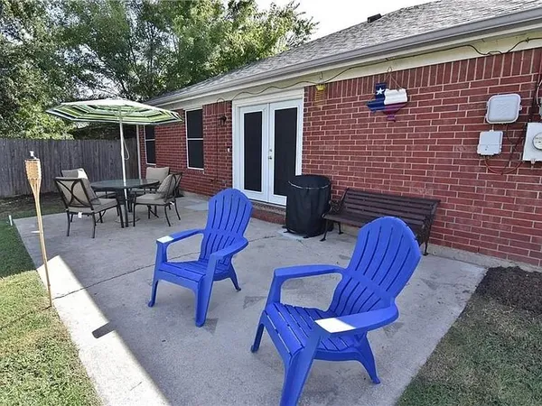 a backyard of a house with table and chairs