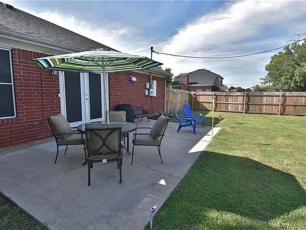 a view of a patio with table and chairs under an umbrella