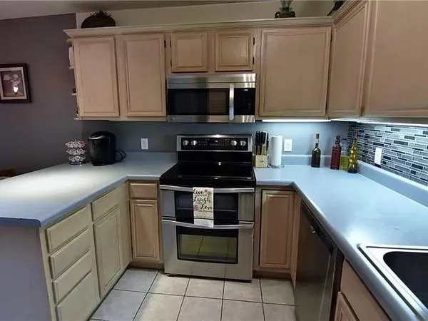 a kitchen with stainless steel appliances granite countertop a sink and a stove top oven
