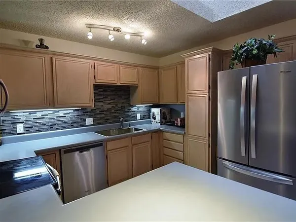 a kitchen with stainless steel appliances granite countertop a refrigerator and a sink