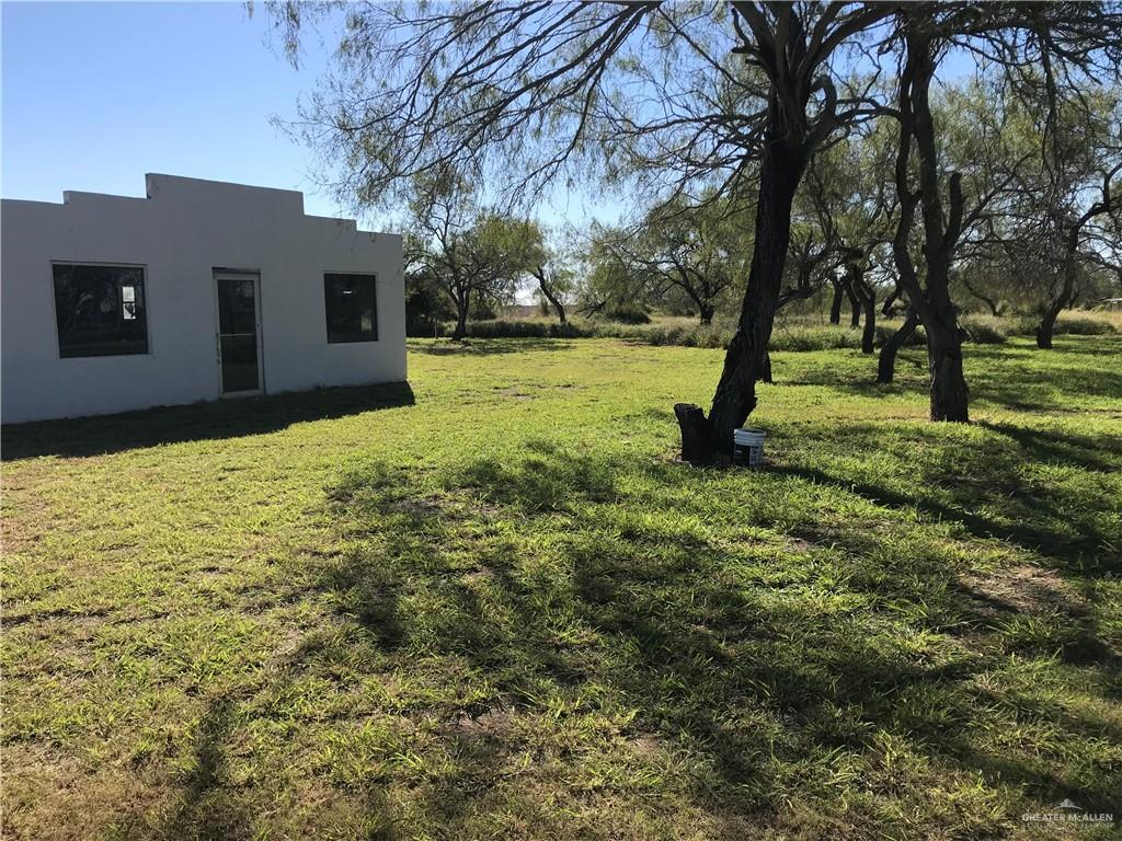 a view of an house with backyard and tree