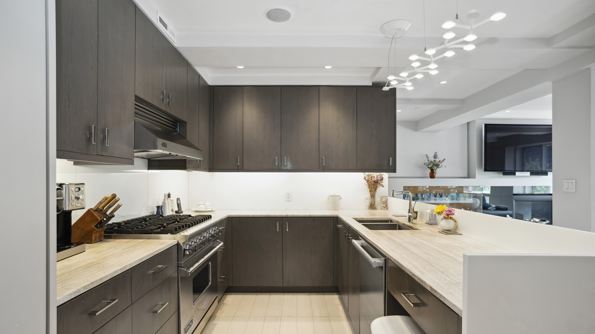 435 East 76th Street, Unit 6A Manhattan, NY 10021 - Photo 4 of 13 a kitchen with a sink a stove and cabinets