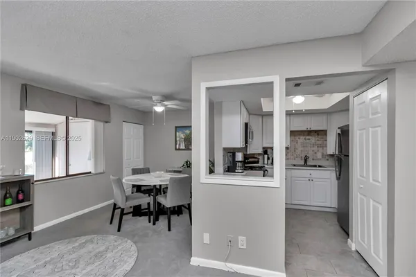 a kitchen with a dining table chairs refrigerator and cabinets