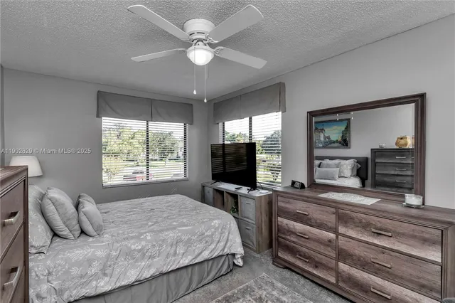 a bedroom with a large bed and a flat tv screen on dresser