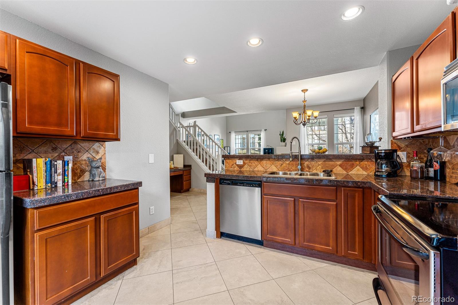 8300 Fairmount Drive, Unit 103 Denver, CO 80247 - Photo 12 of 34 a kitchen with stainless steel appliances granite countertop a stove sink and cabinets