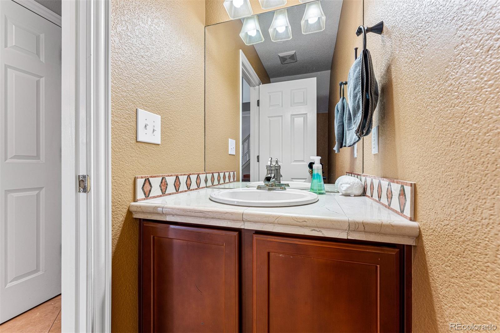 8300 Fairmount Drive, Unit 103 Denver, CO 80247 - Photo 14 of 34 a bathroom with a granite countertop sink and a mirror
