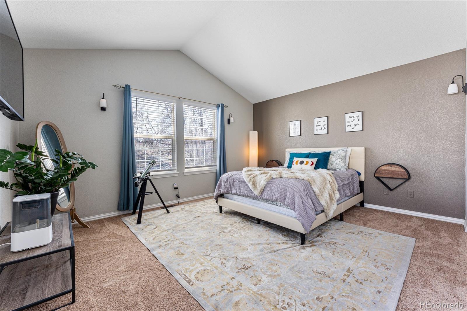 8300 Fairmount Drive, Unit 103 Denver, CO 80247 - Photo 16 of 34 a bedroom with a bed a table and a potted plant