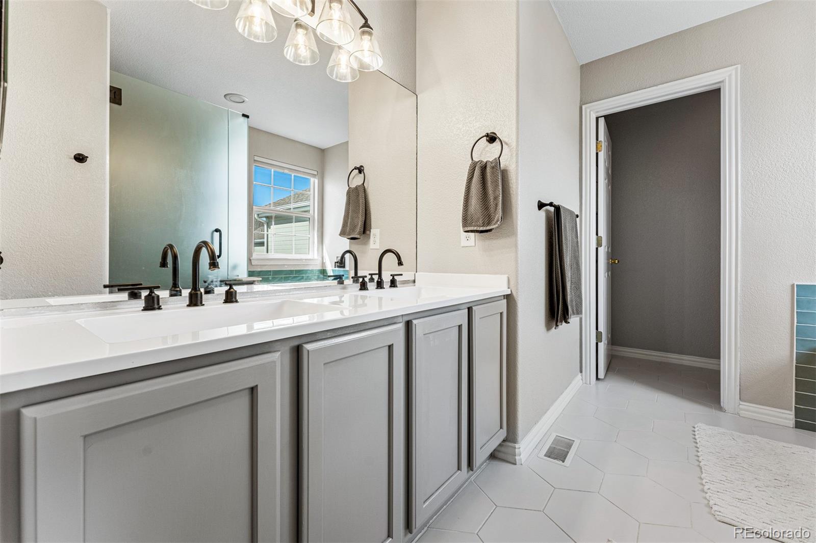 8300 Fairmount Drive, Unit 103 Denver, CO 80247 - Photo 19 of 34 a bathroom with a double vanity sink and a mirror