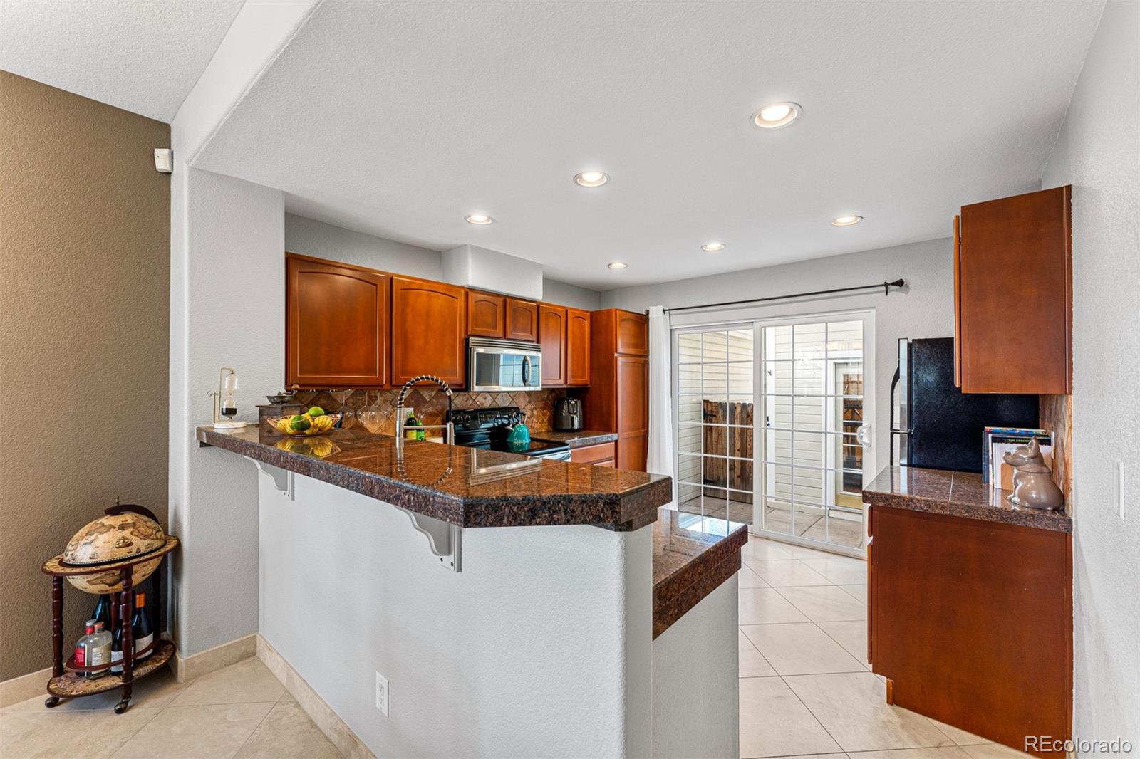 8300 Fairmount Drive, Unit 103 Denver, CO 80247 - Photo 10 of 34 a large kitchen with kitchen island granite countertop a large window and a sink