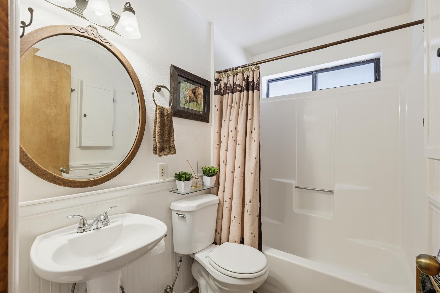 4838 Golden Street Pollock Pines, CA 95726 - Photo 20 of 35 a bathroom with a sink a mirror a toilet and a shower