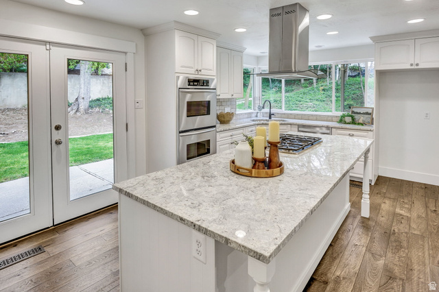 1320 Canyon Park Road Bountiful, UT 84010 - Photo 9 of 28 Kitchen featuring white cabinets, island range hood, light wood-style flooring, recessed lighting, and light stone countertops