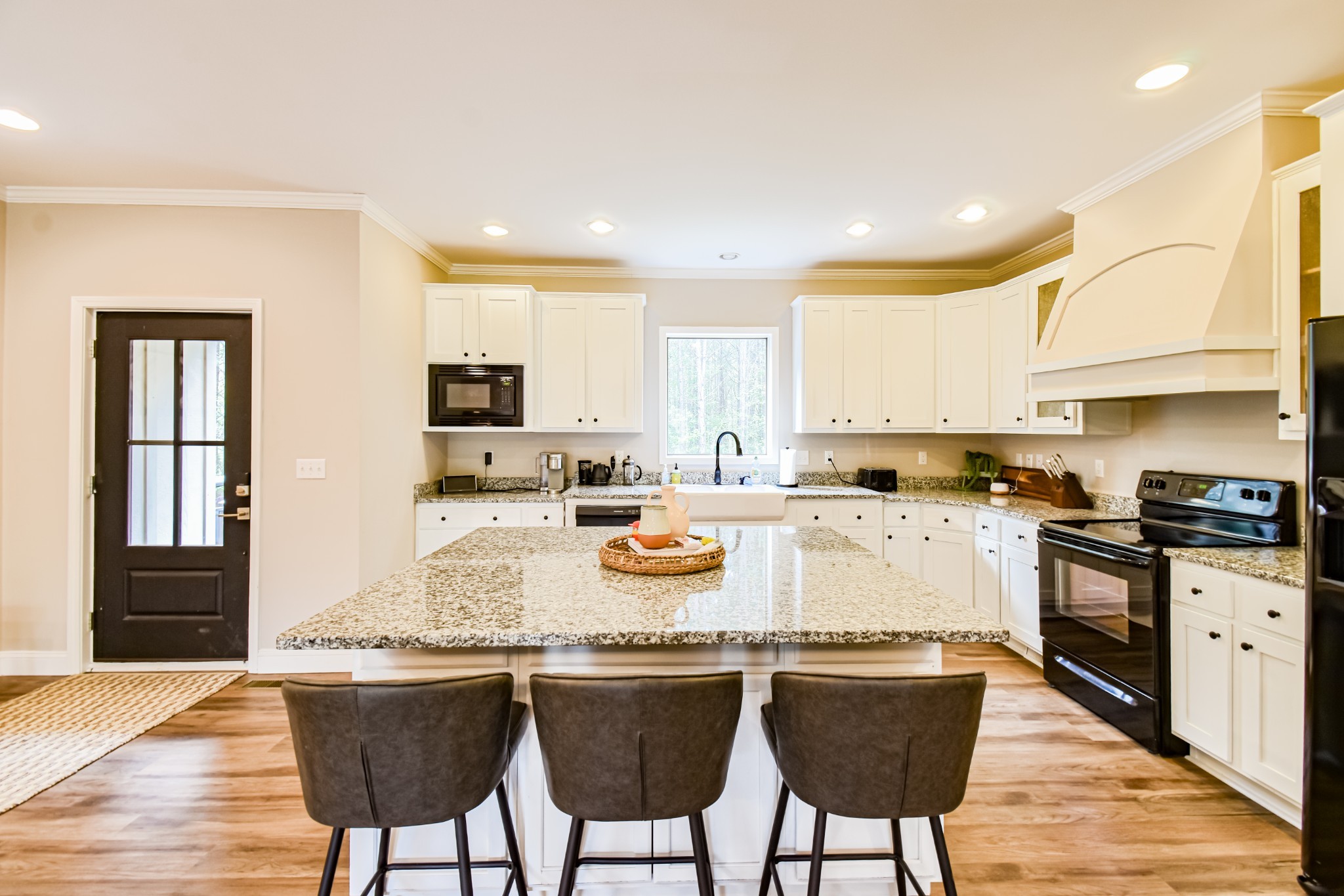 920 Mason Bates Bend Road Centerville, TN 37033 - Photo 11 of 44 a kitchen with stainless steel appliances granite countertop a stove top oven a sink a refrigerator white cabinets and chairs with wooden floor