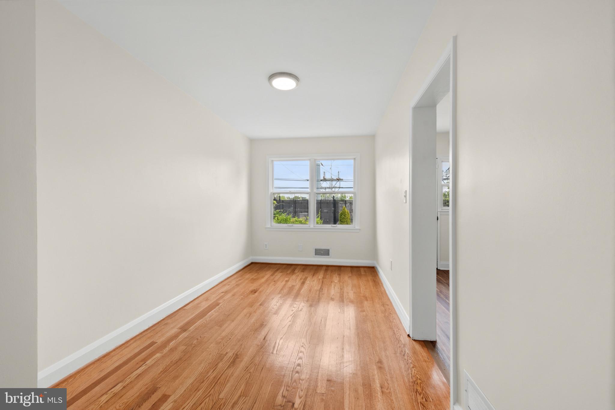 2207 Hawthorne Road Baltimore, MD 21220 - Photo 8 of 39 a view of an empty room with wooden floor and a window