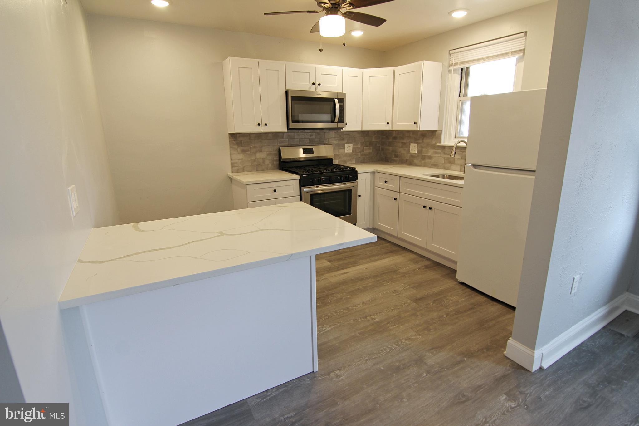 135 West 4th Street, Unit 2E Bridgeport, PA 19405 - Photo 6 of 11 a kitchen with a sink a stove top oven and white kitchen