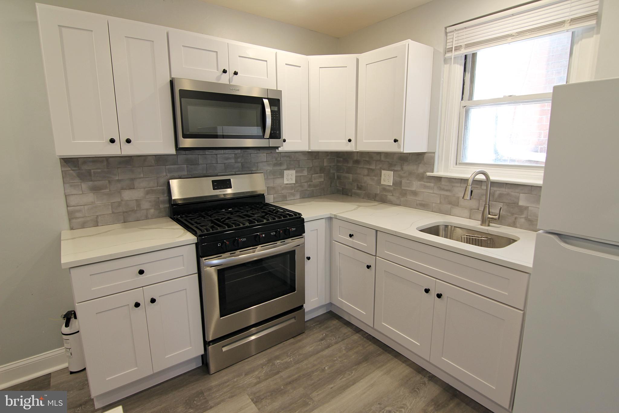 135 West 4th Street, Unit 2E Bridgeport, PA 19405 - Photo 7 of 11 a kitchen with white cabinets appliances and a sink