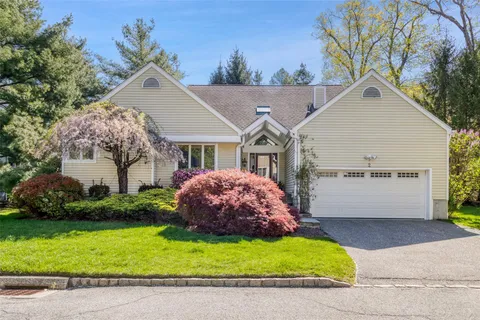 a view of a white house next to a yard and trees