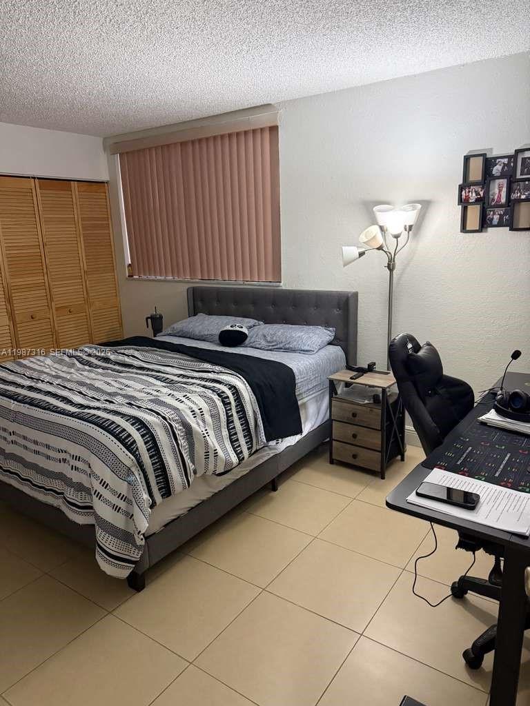 1900 West 68th Street, Unit A205 Hialeah, FL 33014 - Photo 5 of 6 a bedroom with a bed and a chandelier