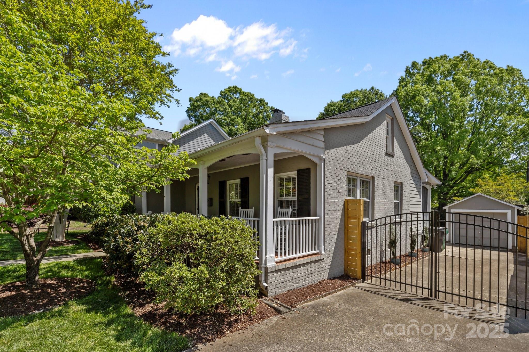 3019 Sunset Drive Charlotte, NC 28209 - Photo 39 of 46 a view of a white house with large windows and a small yard