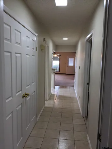 a view of a hallway with wooden shelves