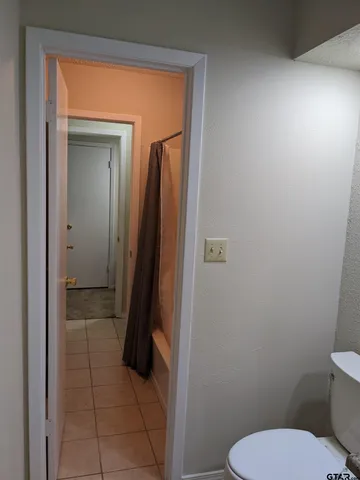 a bathroom with a toilet and a shower