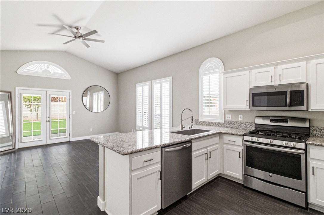 9523 Observer Street Las Vegas, NV 89123 - Photo 10 of 42 A well-lit kitchen with granite countertops and stainless steel appliances, seamlessly connects to outdoor living.